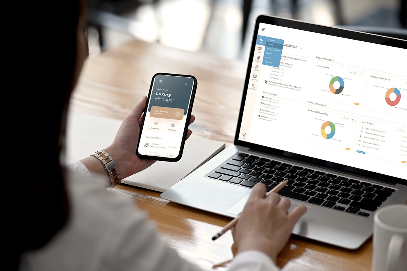 Woman looking at data on a laptop and smart phone.