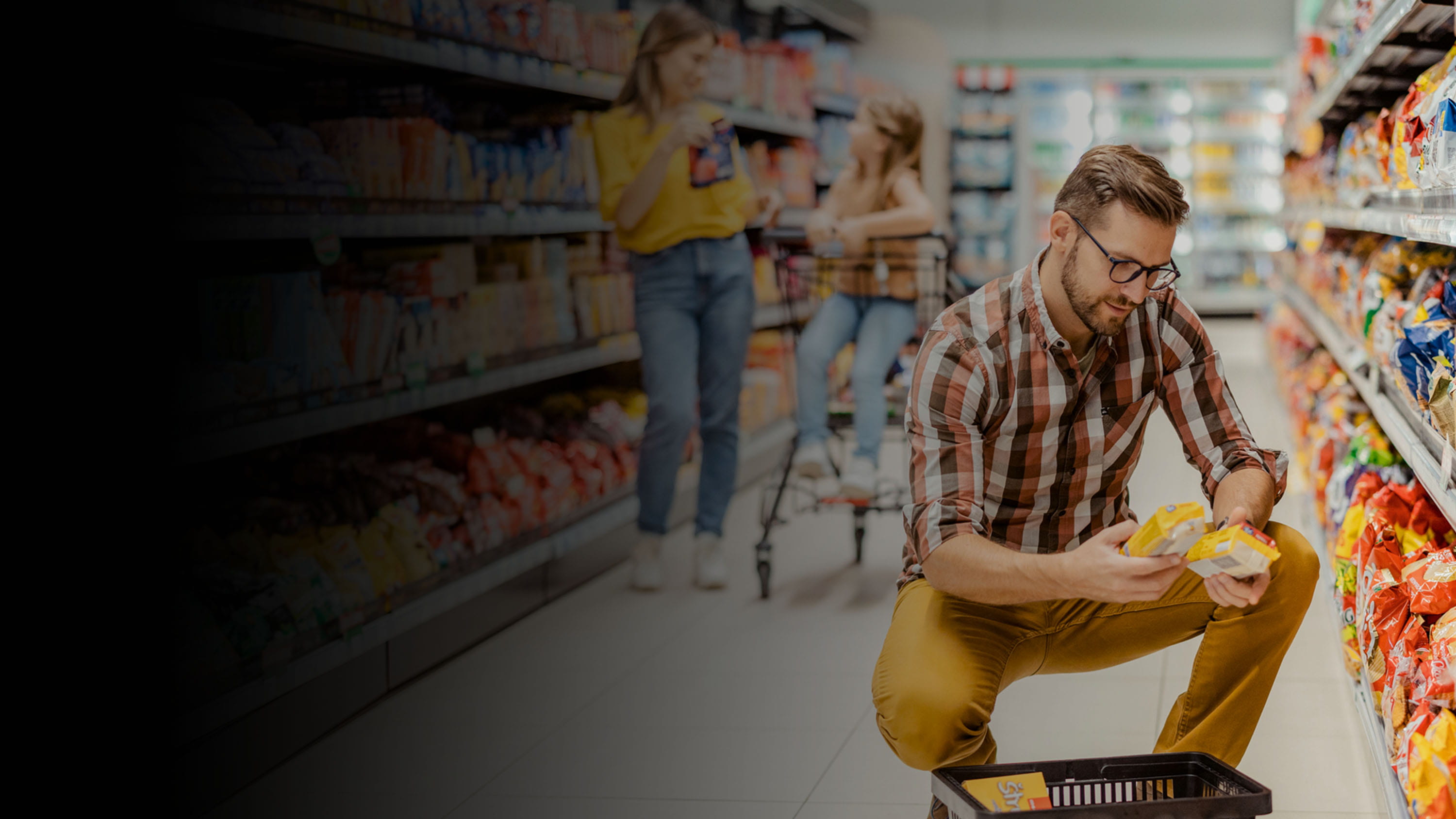 Customers in a grocery store aisle shopping.