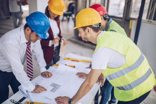 Several people in hardhats looking at plans