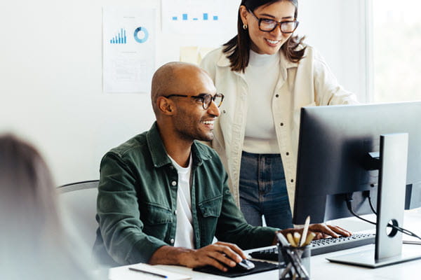 Young coworkers working on a computer.