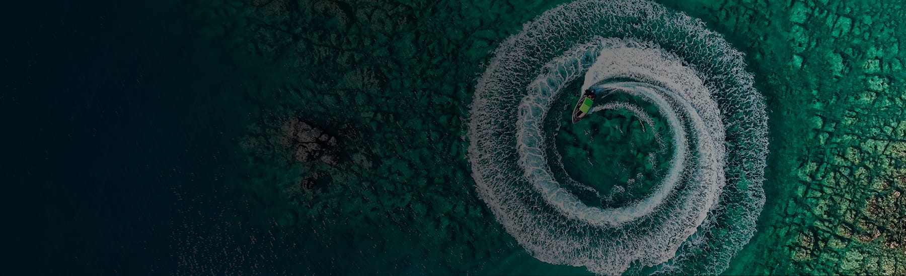 A jetski leaving a spiral of ripples in the water, gradient.