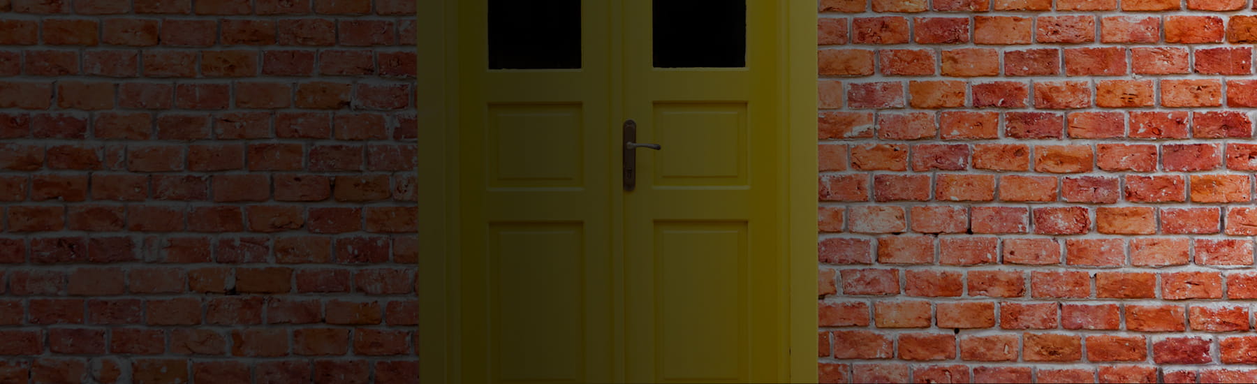 Yellow door on a brick wall