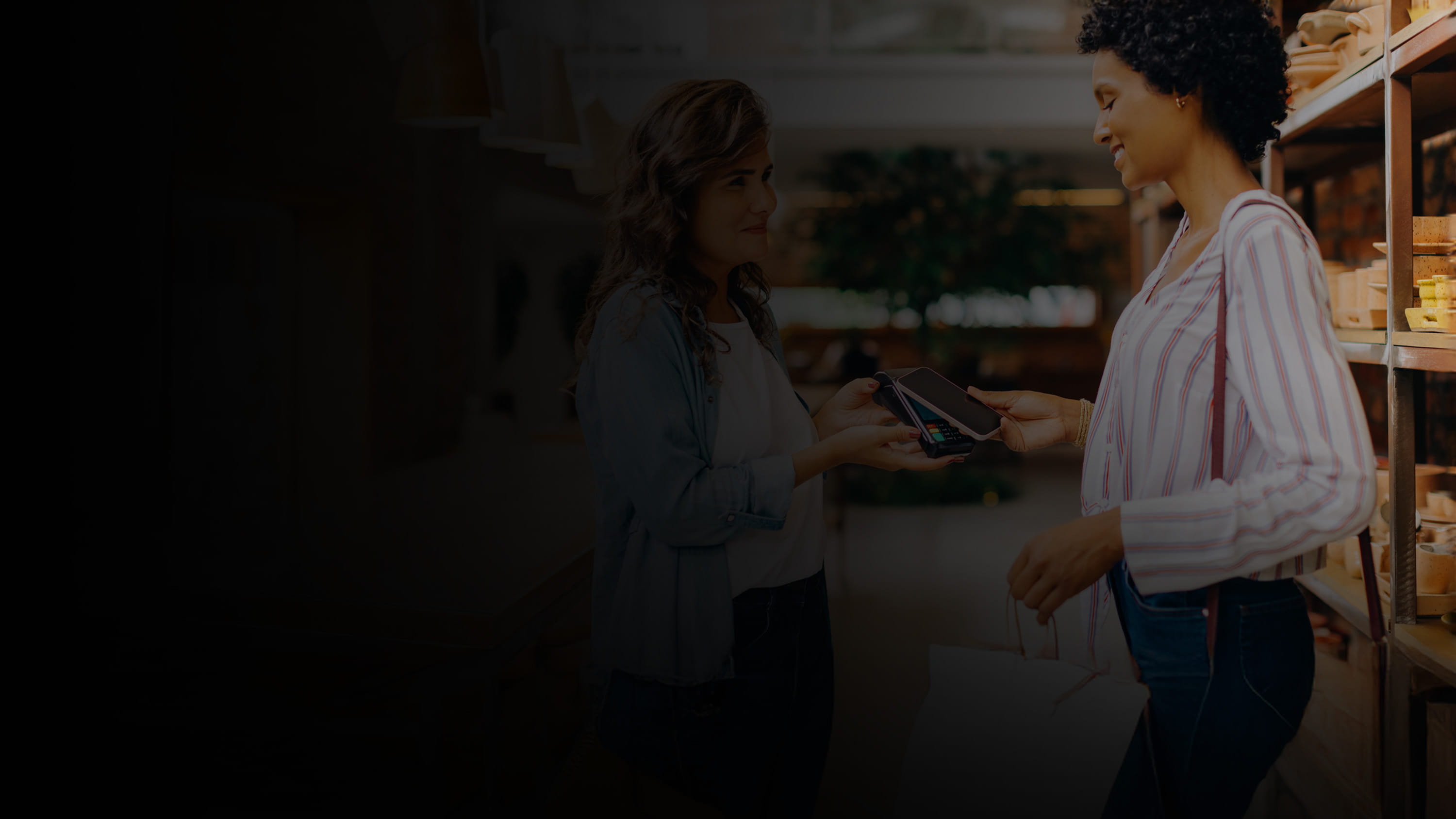 A woman using a phone to pay for her purchases.