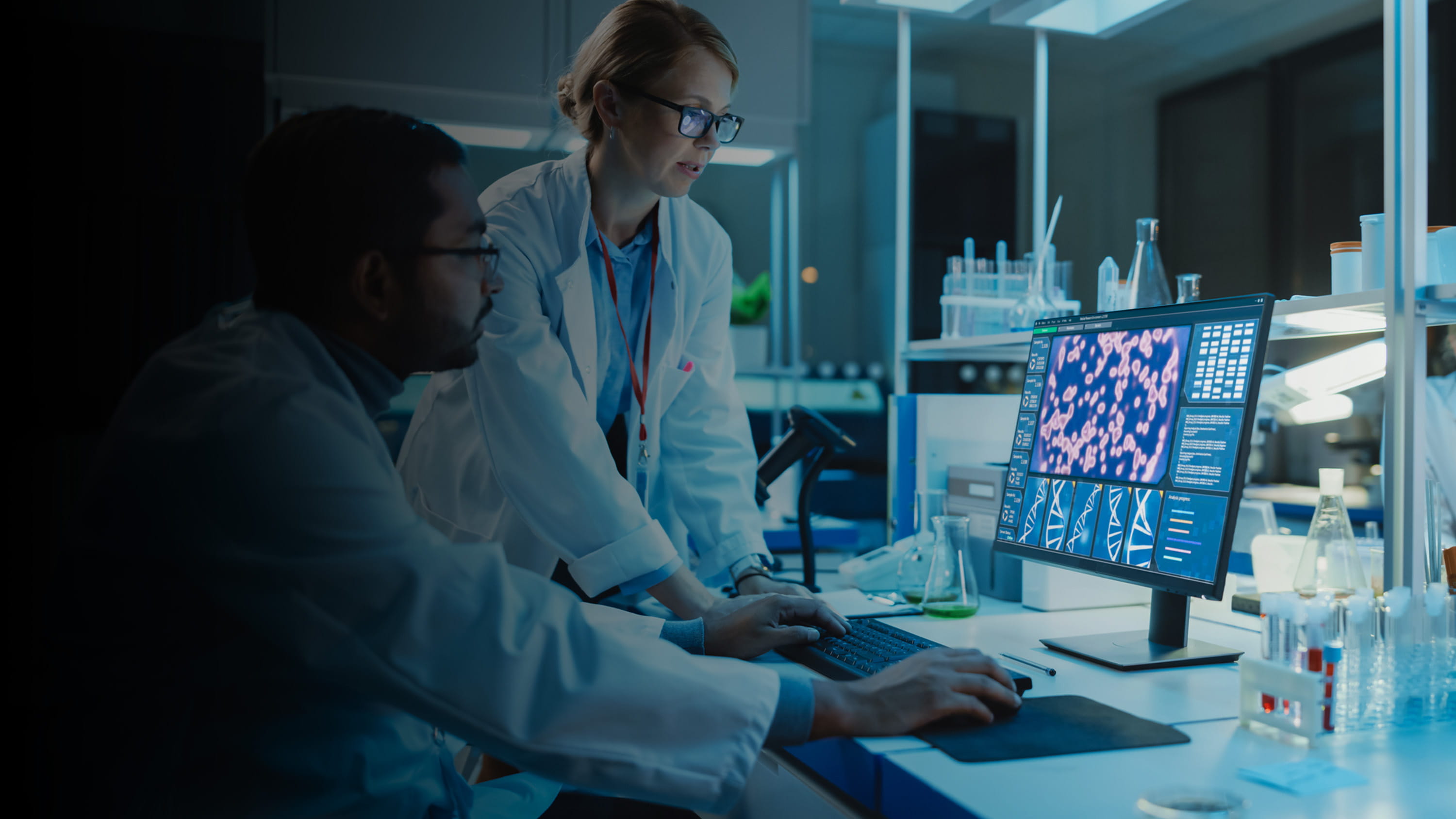 Doctors looking at scans and research on a computer.