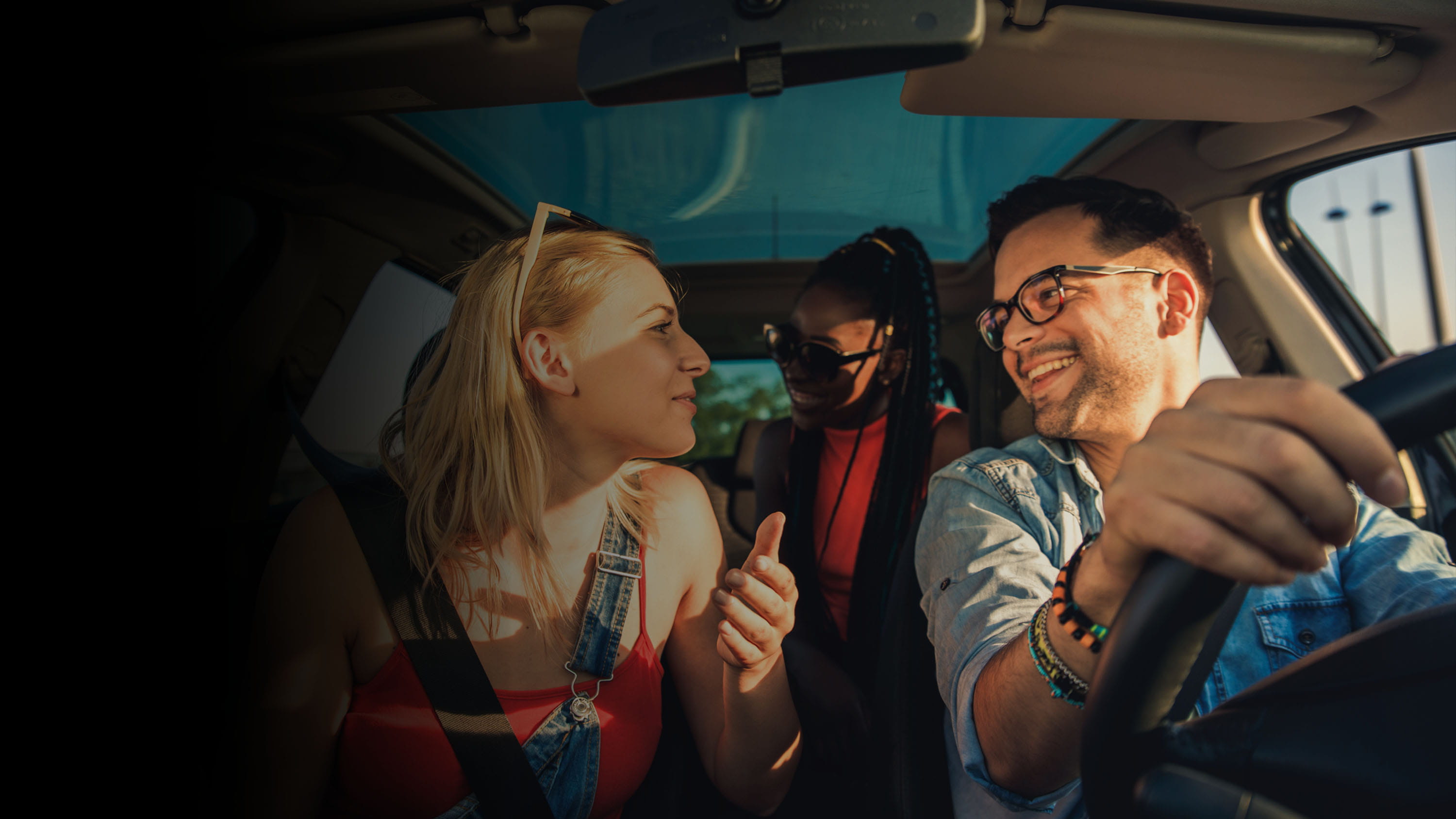 3 people sitting inside a car