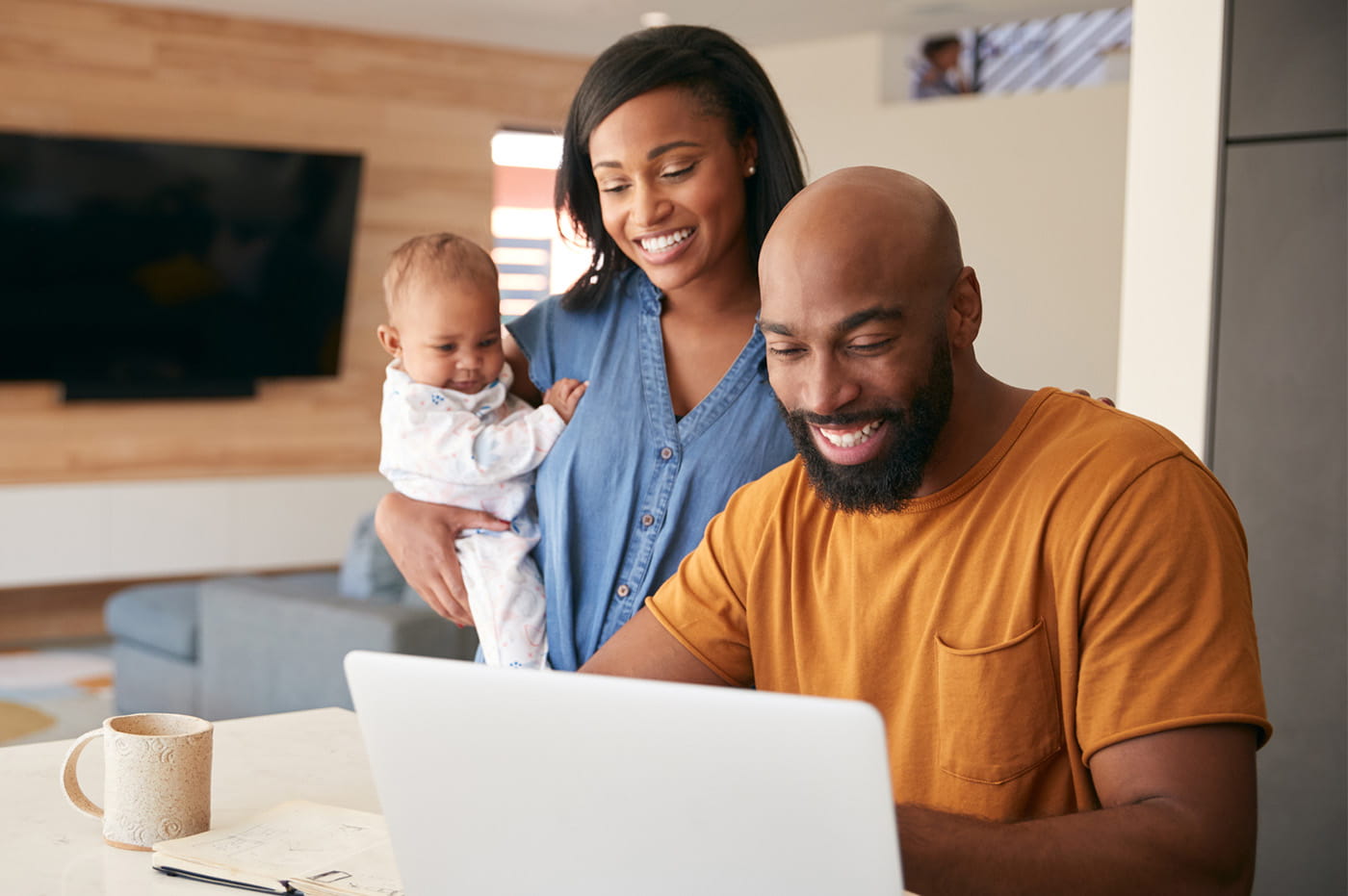 Young couple with a baby sitting in front of a computer