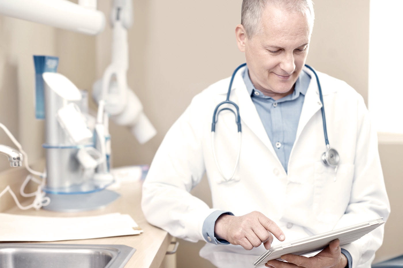 Dentist working on an iPad in a dental office.