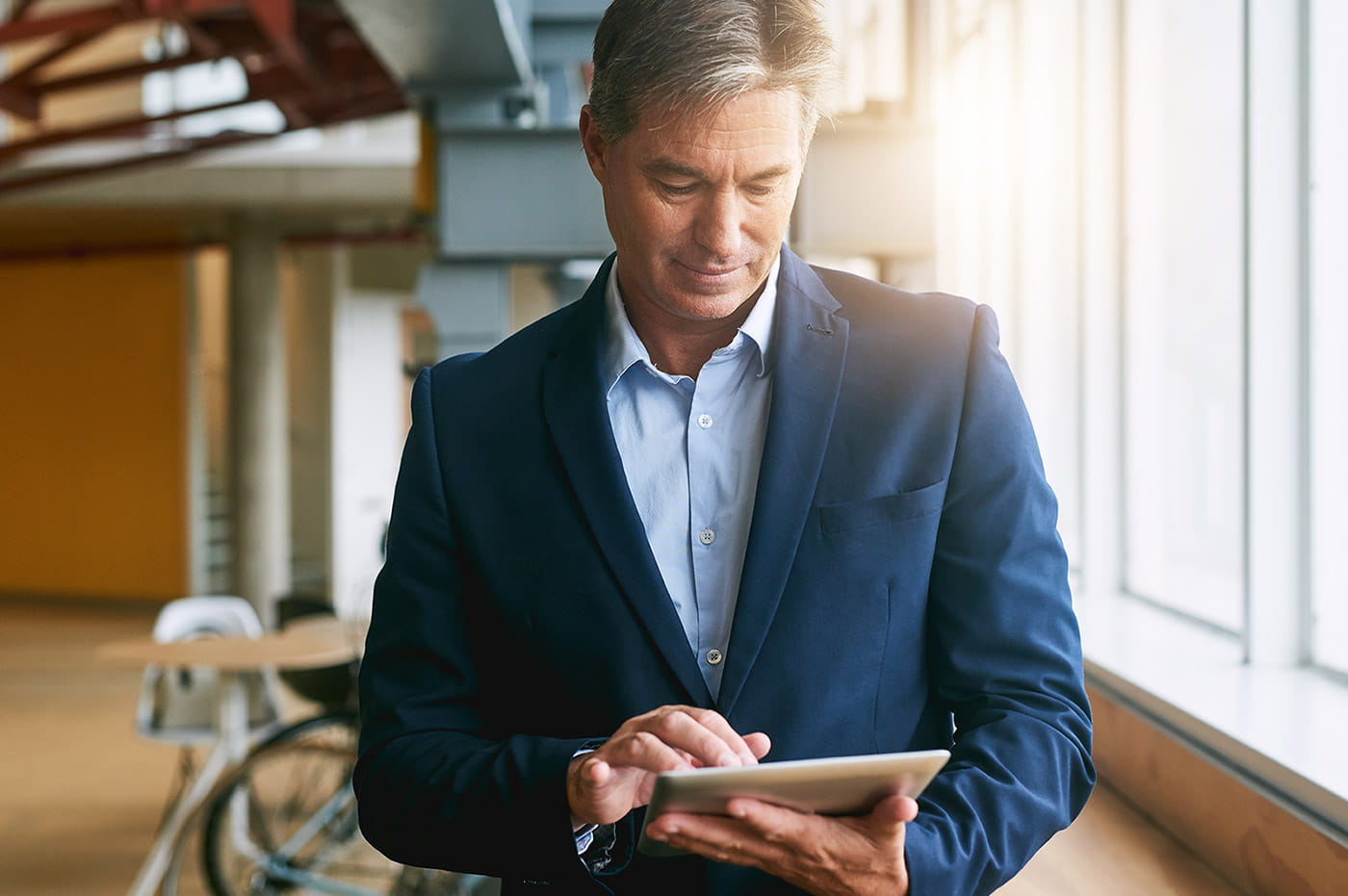 Business man in suit working on an iPad.