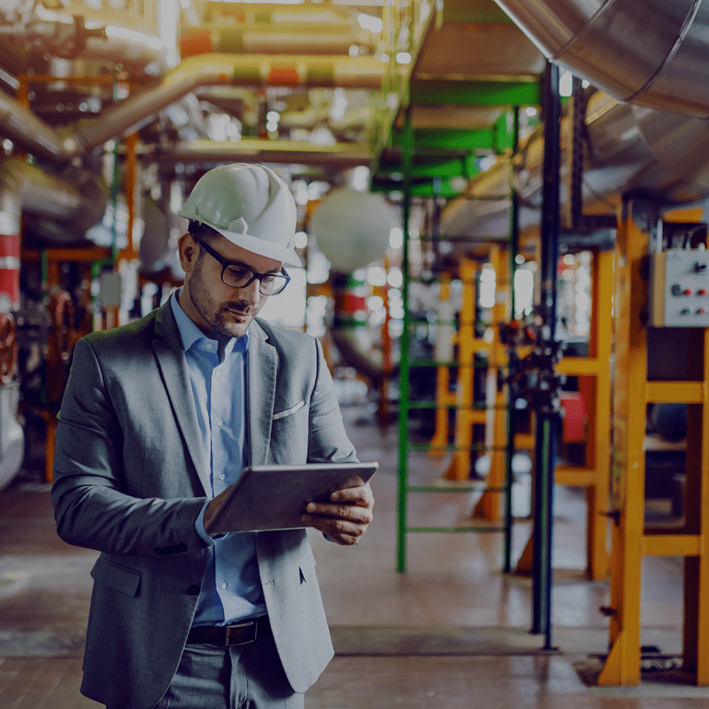 Man with a hard hat on in an oil factory