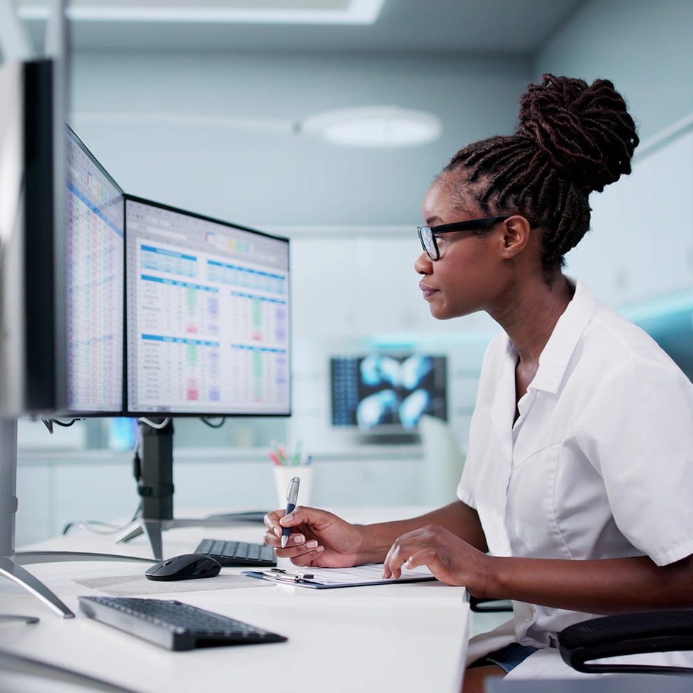 Woman looking at multiple computer monitors