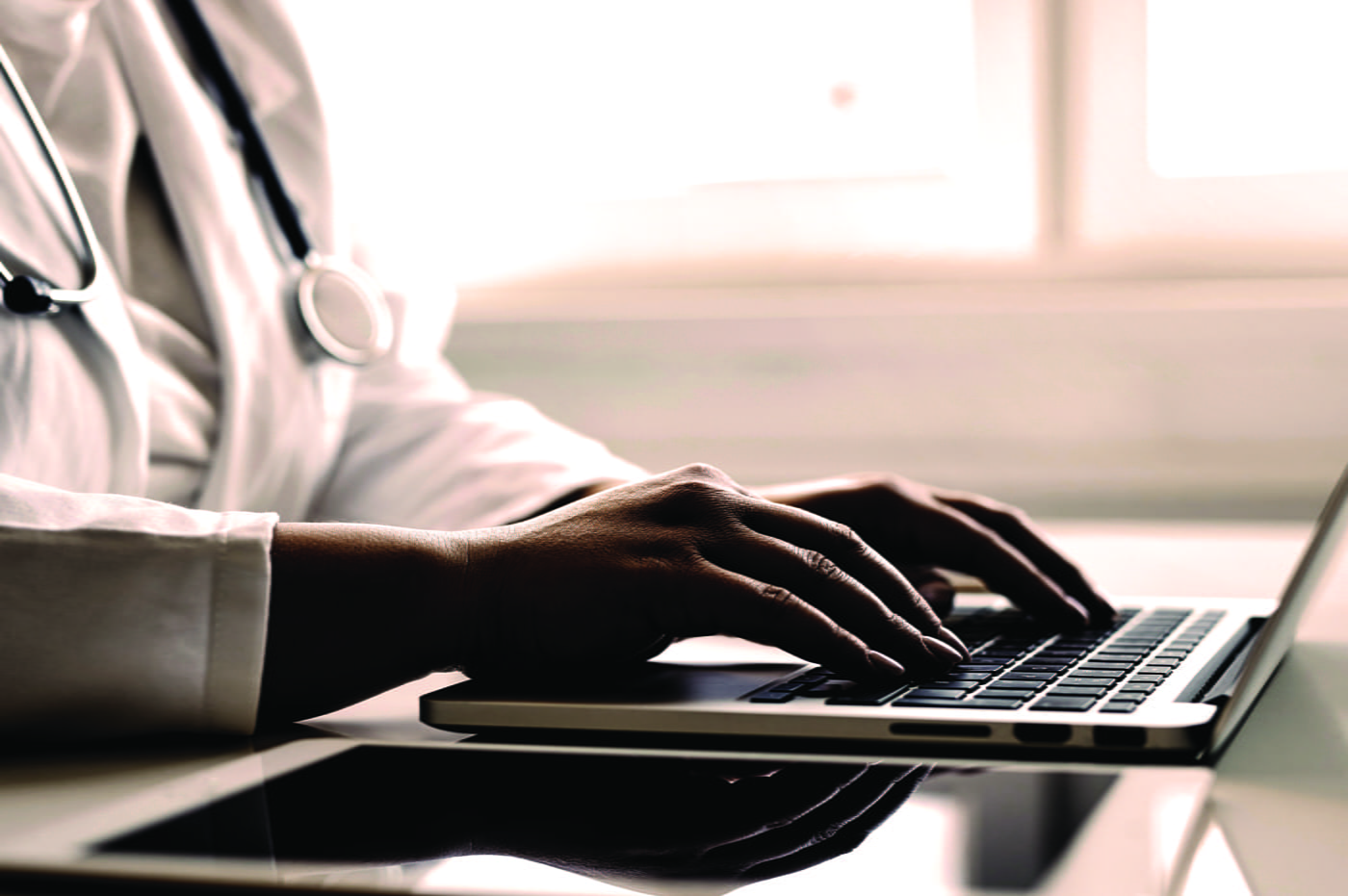 A doctor typing on a keyboard.