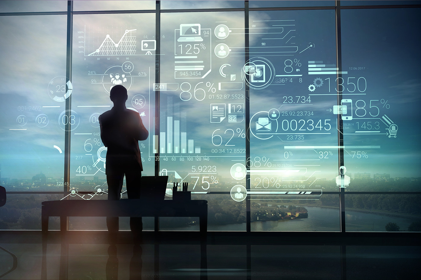 A man standing looking out a window with tech images on a window. 