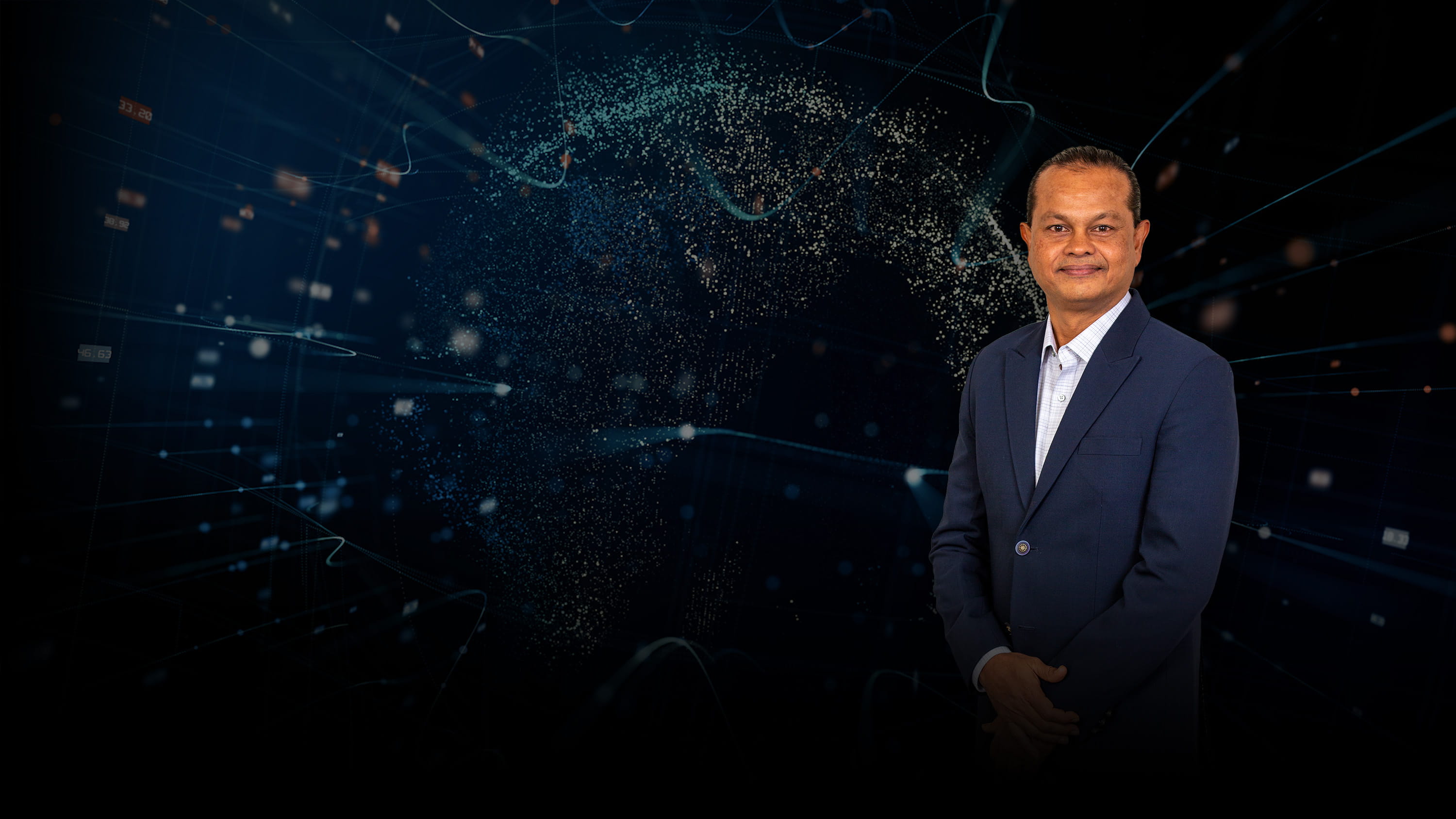 Prakash Chembai in front of an abstract background.