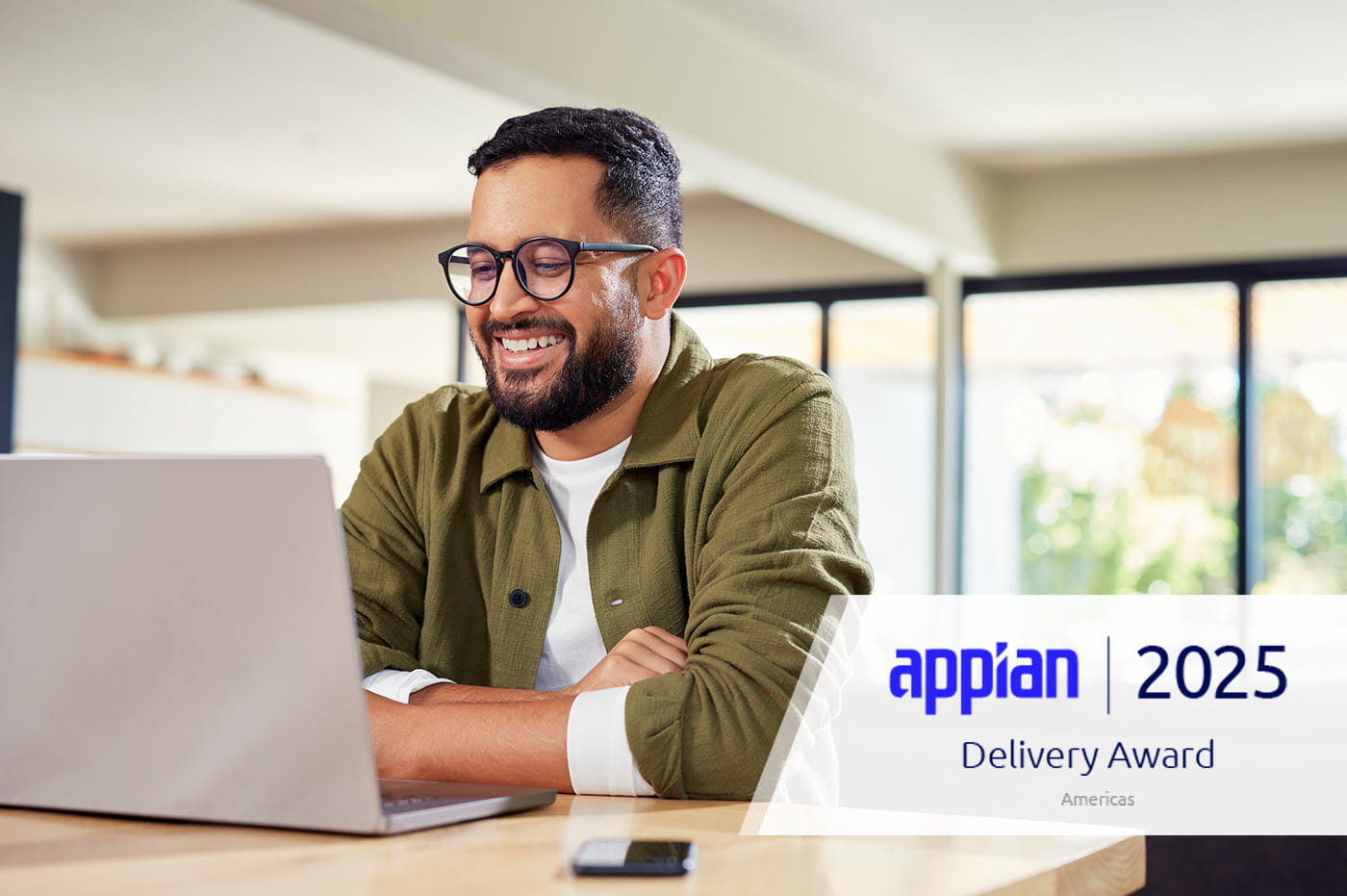 2025 Appian Delivery award badge mounted on image of a man on a laptop.