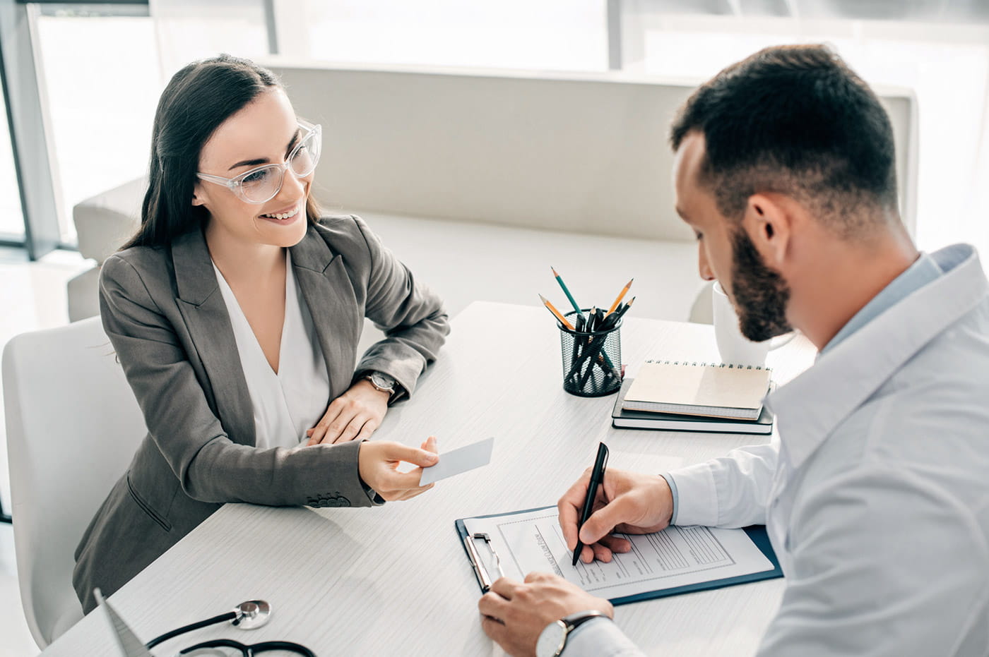 A woman and a doctor going over insurance information together.