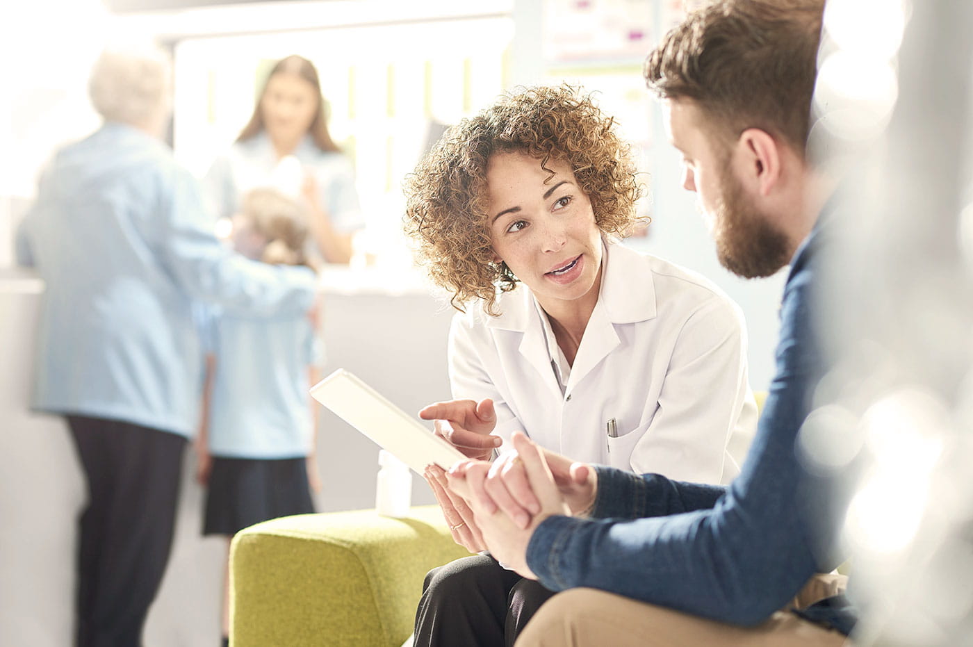 A female doctor going over paperwork with a male patient.